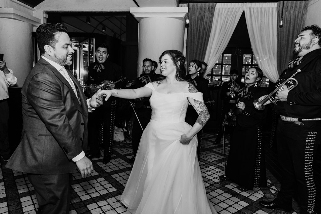 Black and white photo of bride and groom dancing while Mariachi EDC plays at their Osteria Via Stato wedding reception