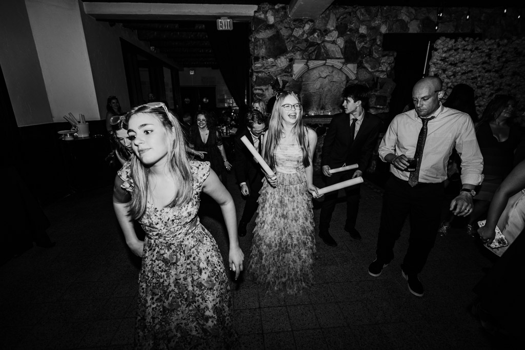Guests dancing during wedding reception at Osteria Via Stato, some holding glow sticks