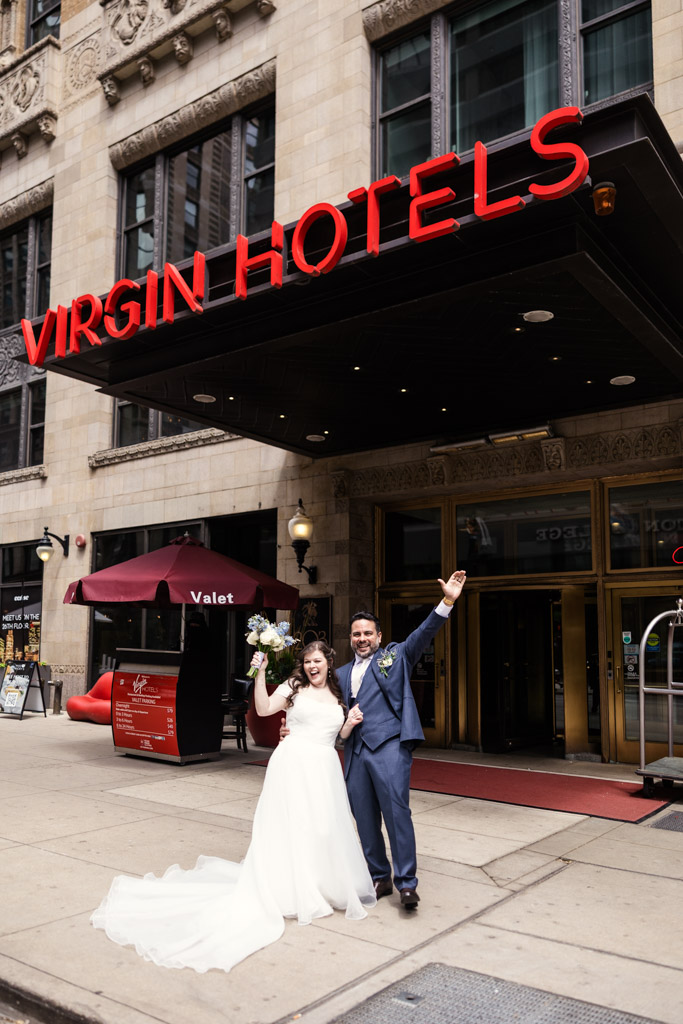 Bride and groom celebrating outside the Virgin Hotels entrance on a city sidewalk, just steps away from Osteria Via Stato.