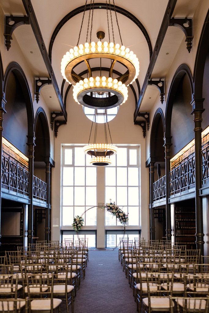 The Library at 190 wedding ceremony space with chandeliers, arched details, and rows of chairs facing a floral altar