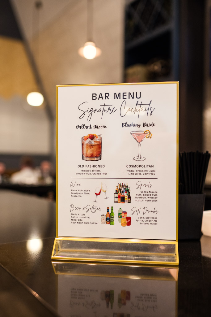 Custom bar menu at The Library at 190 wedding, featuring signature cocktails, wine, beer, seltzers, spirits, and soft drinks on the counter