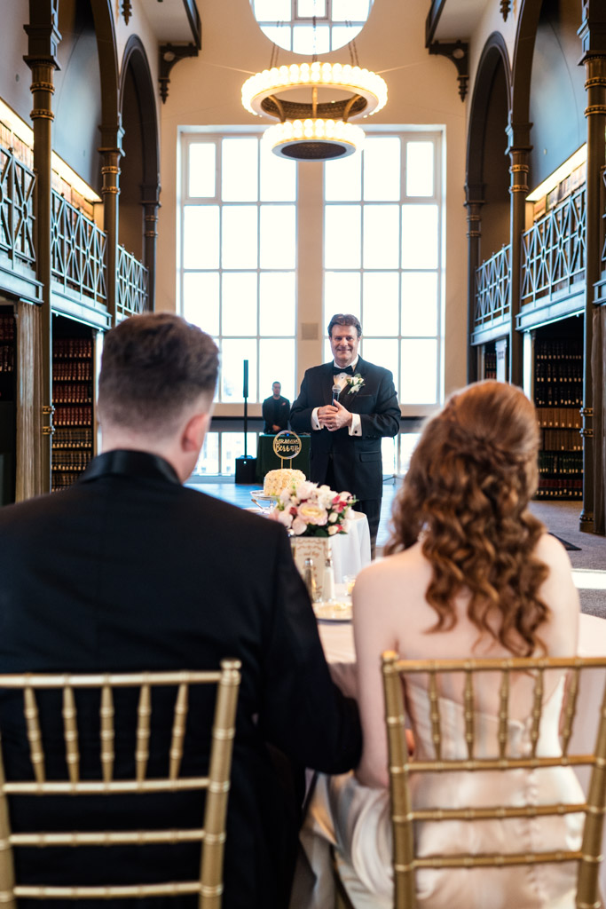 Newlyweds listen as bride's father gives a speech at their wedding reception at The Library at 190 in downtown Chicago