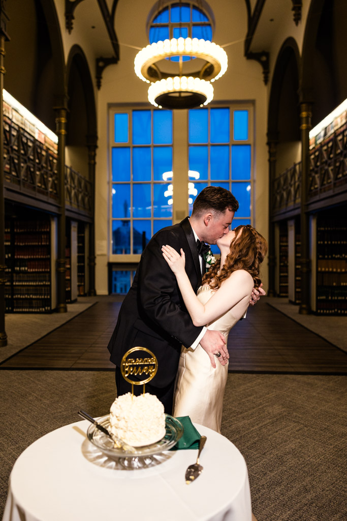 Newlyweds kiss after cutting their cake during their wedding reception at The Library at 190 in downtown Chicago