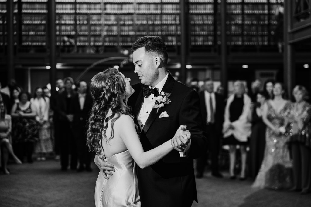 Black and white photo of bride and groom during their first dance, surrounded by guests iat The Library at 190 in downtown Chicago