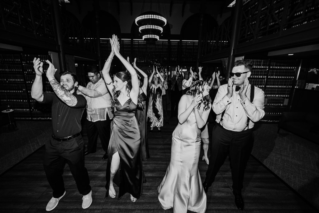 Black and white photo of bride, groom and guests on the dance floor during The Library at 190 wedding reception in downtown Chicago