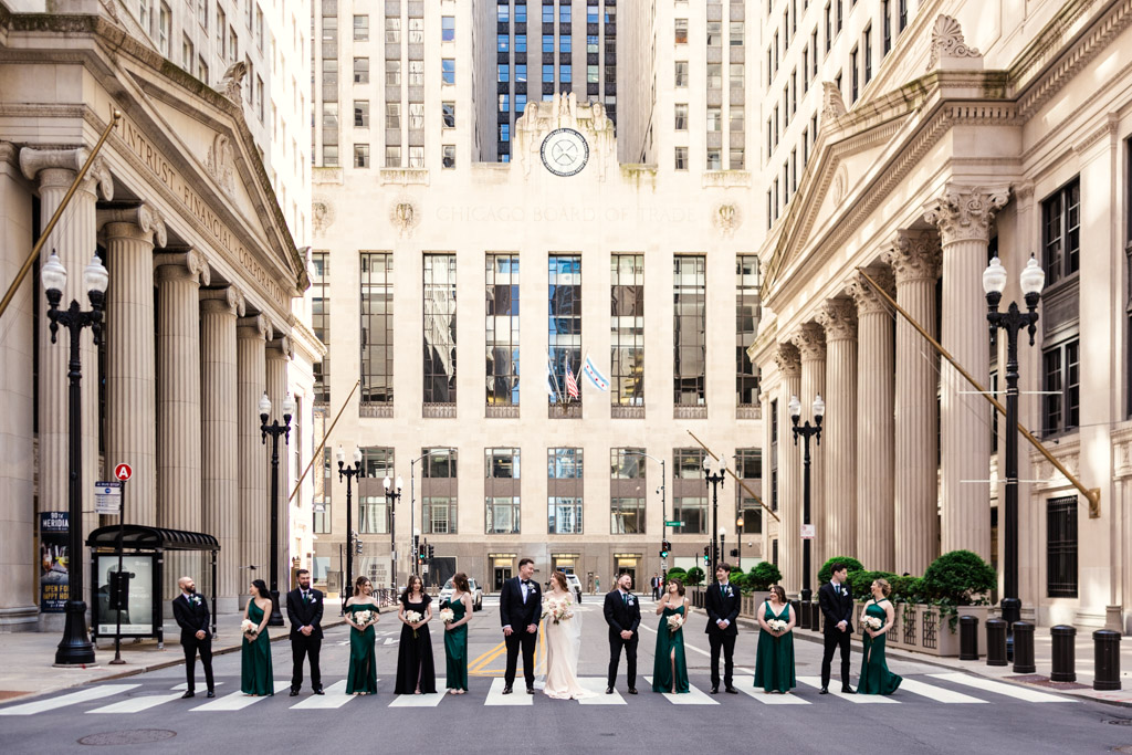 Portrait of wedding party on a crosswalk in front of the Chicago Board of Trade Building