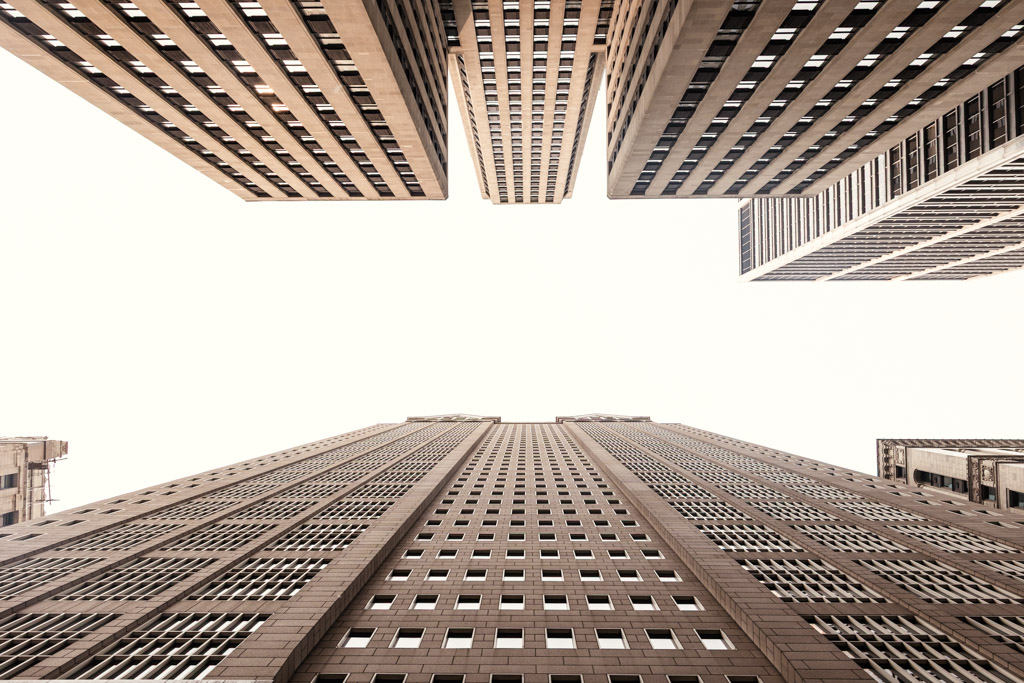 Upward view of tall skyscrapers with many windows against a bright, clear skyin downtown Chicago