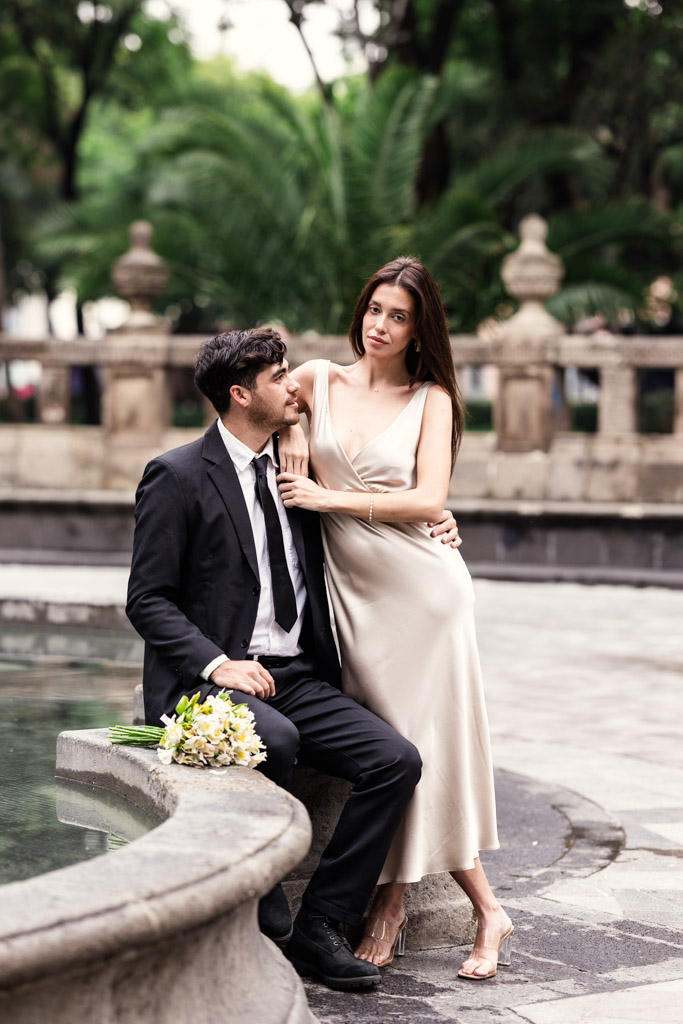 Newlywed couple poses by a fountain in Alameda Central during their Mexico City elopement