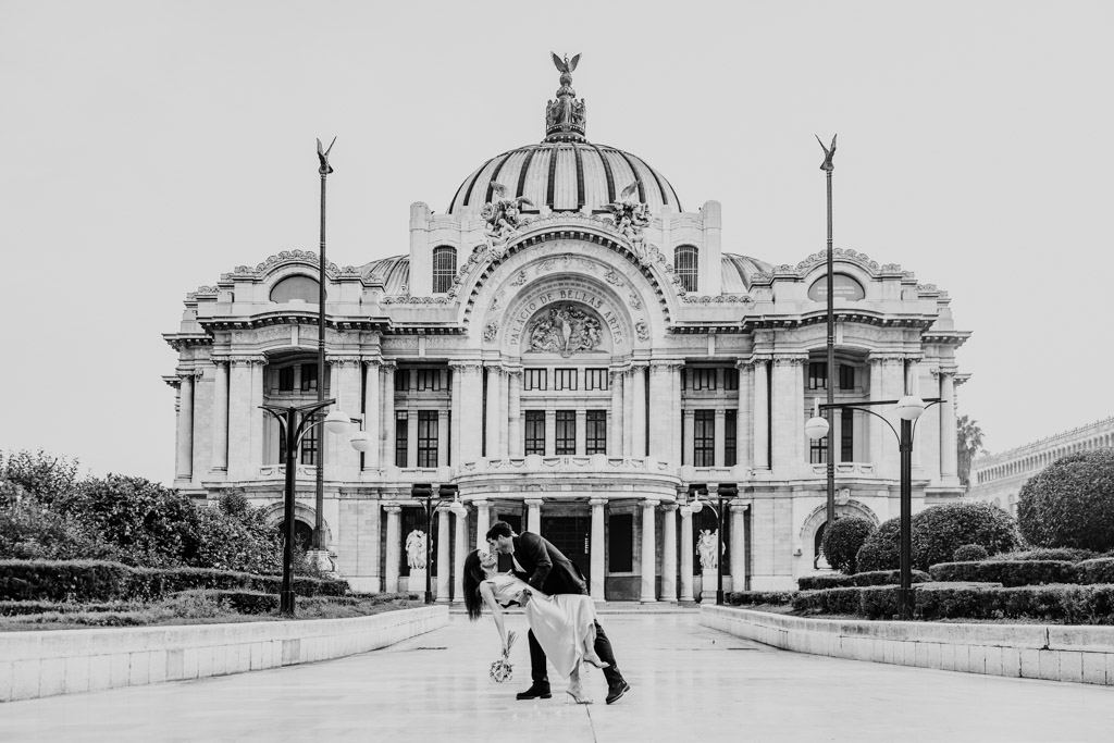 Romantic black and white photo of man dipping his partner in front of Palacio de Bellas Artes during their Mexico City elopement session