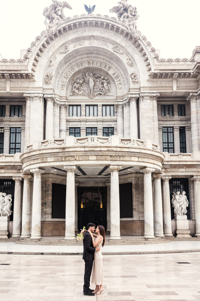 Couple embracing in front of the Palacio de Bellas Artes during their Mexico City elopement
