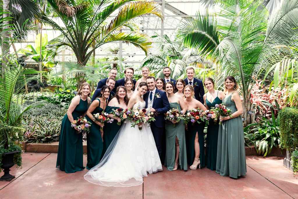 Wedding party portrait inside Garfield Park Conservatory, surrounded by greenery