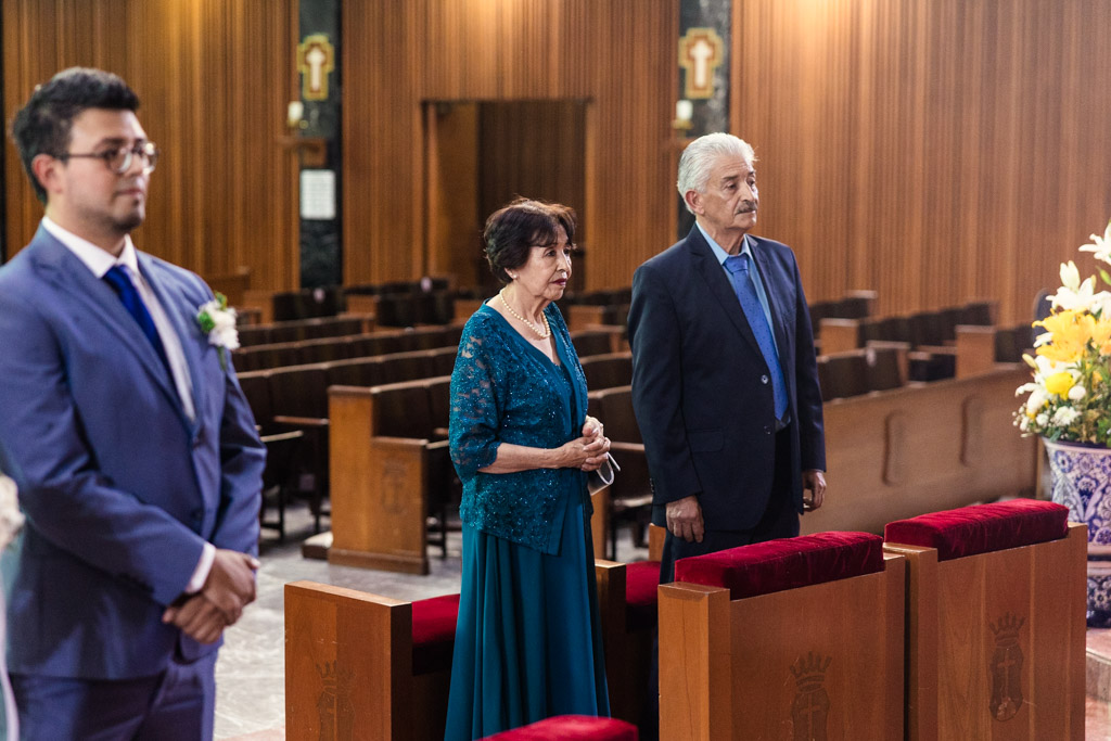 Groom's parents stand near him during wedding ceremony at Parroquia San Cayetano