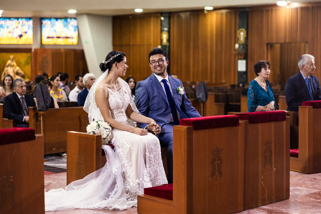 Bride and groom sit smiling together inside Parroquia San Cayetano during their Mexico City wedding ceremony