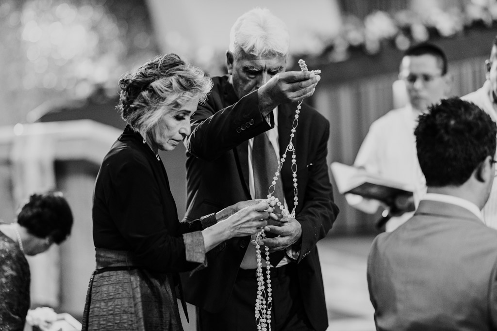Guests prepare a large rosary cord for El Lazo ceremony during wedding mass at Parroquia San Cayetano