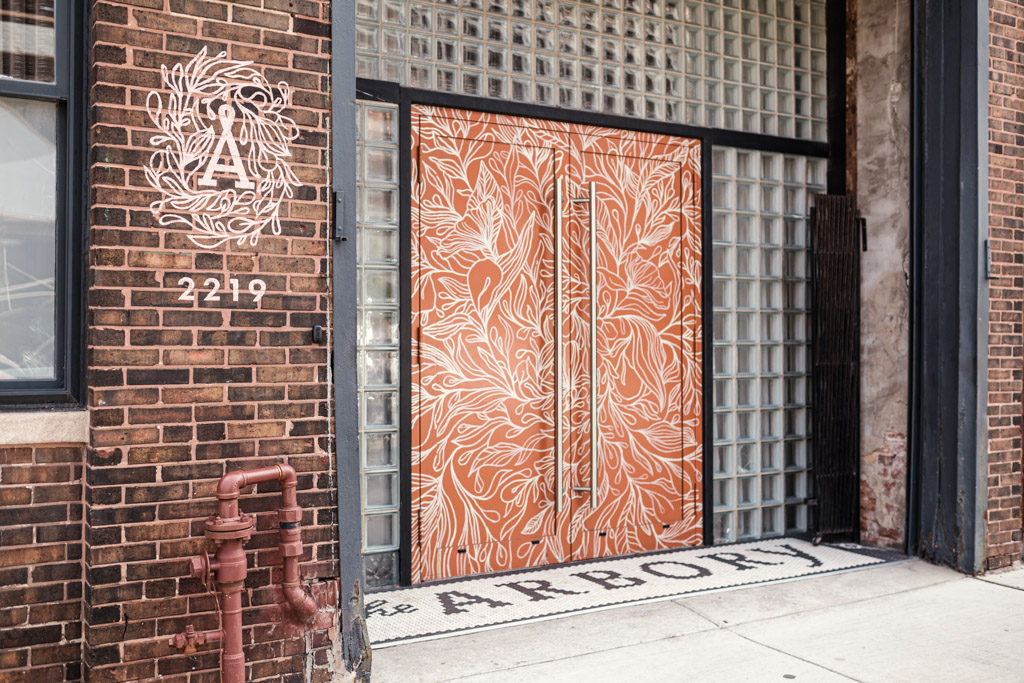 Orange double doors with white floral designs, glass block wall, and 