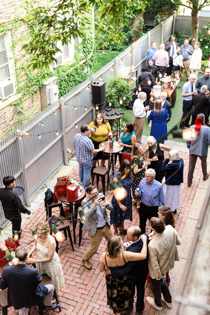 Guests socializing at a summer wedding reception at Firehouse Chicago, surrounded by greenery