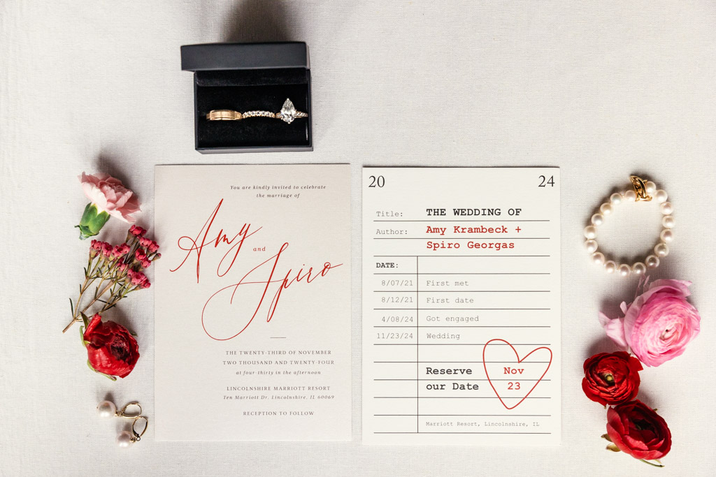 Wedding invite flat lay featuring a rings, flowers, a bracelet, and save-the-date cards for Lincolnshire Marriott Resort wedding
