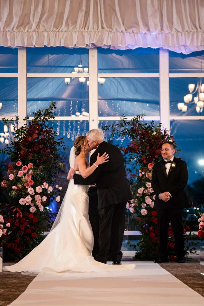 Bride's father kisses bride's cheek during wedding ceremony at Lincolnshire Marriott Resort