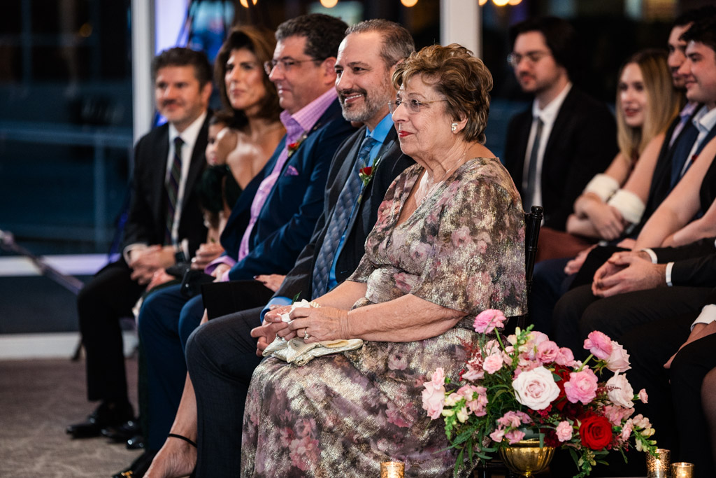 Groom's family dressed formally sit and smile during wedding ceremony at Lincolnshire Marriott Resort