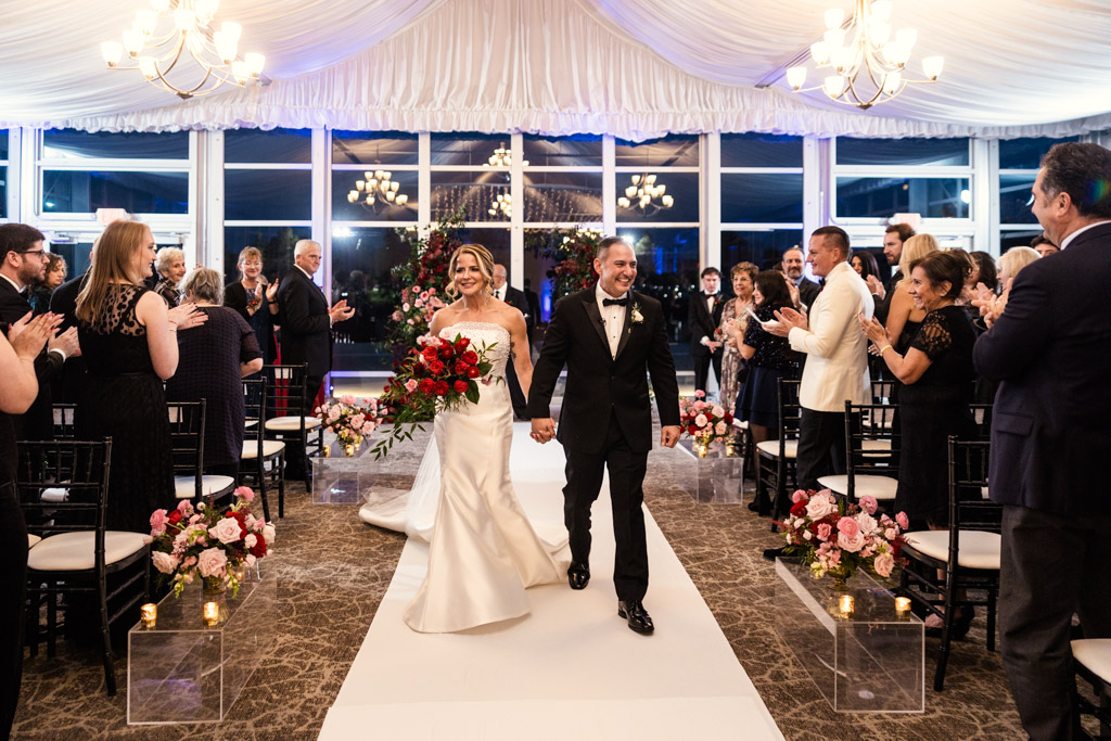Newlywed couple walks down the aisle as guests stand and applaud at Lincolnshire Marriott Resort