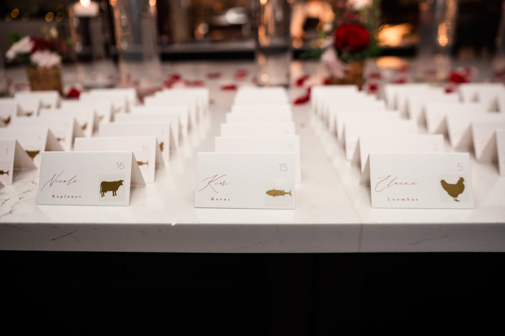 Rows of white place cards with gold animal icons and names are on a marble table for wedding reception at Lincolnshire Marriott Resort