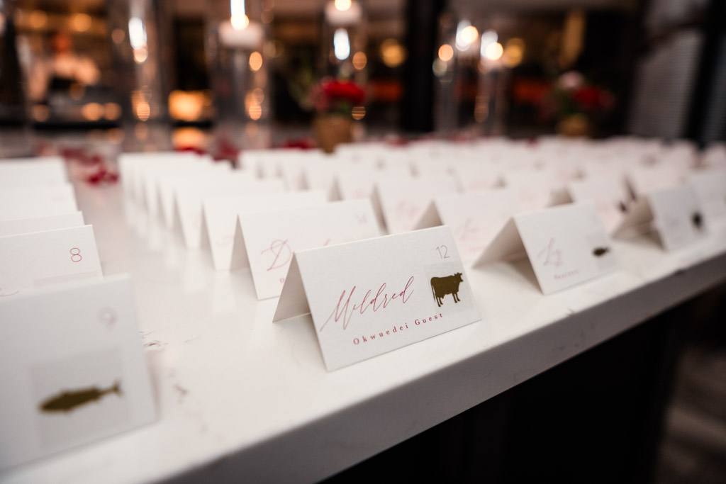 Rows of white place cards with names and table numbers on a marble surface for Lincolnshire Marriott Resort wedding reception