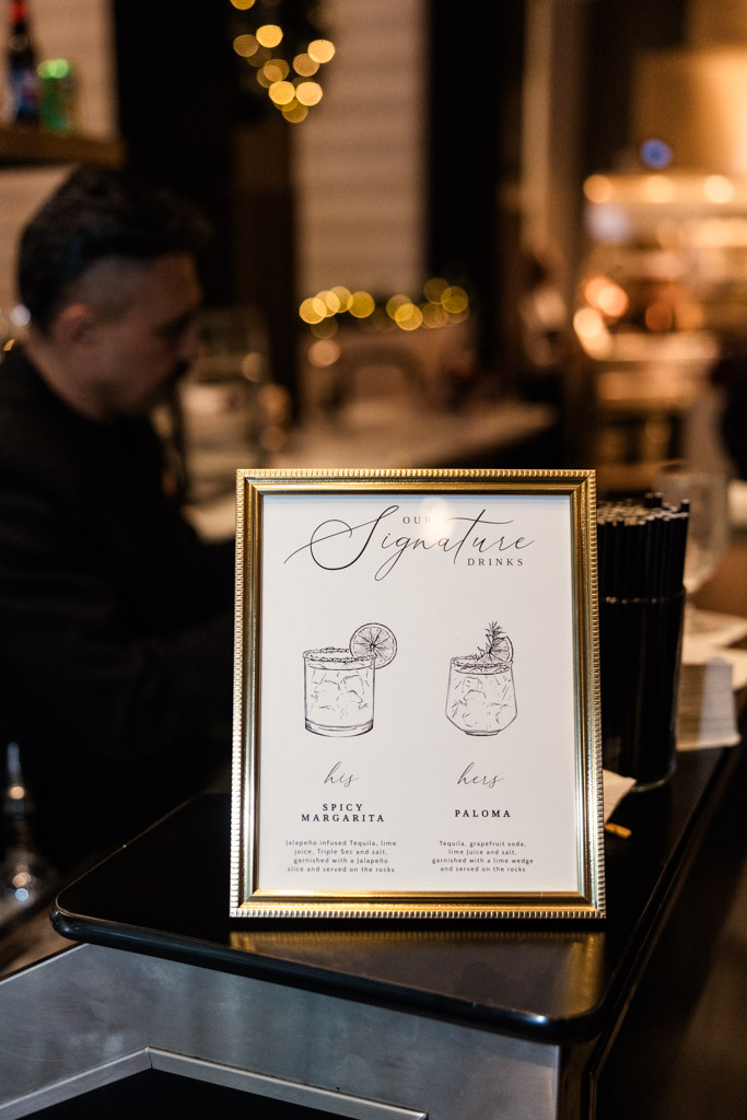 Framed signature cocktail menu on the Marriott Lincolnshire bar counter, featuring Spicy Margarita and Paloma illustrations.