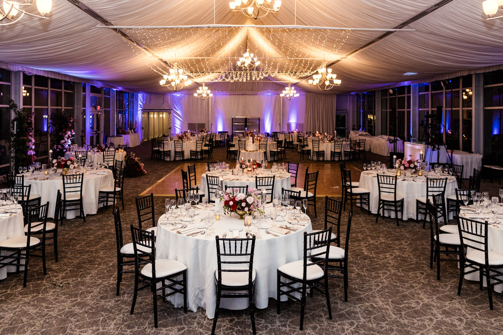 Wedding reception space at Lincolnshire Marriott Resort, with round tables under draped ceiling and chandelier lighting