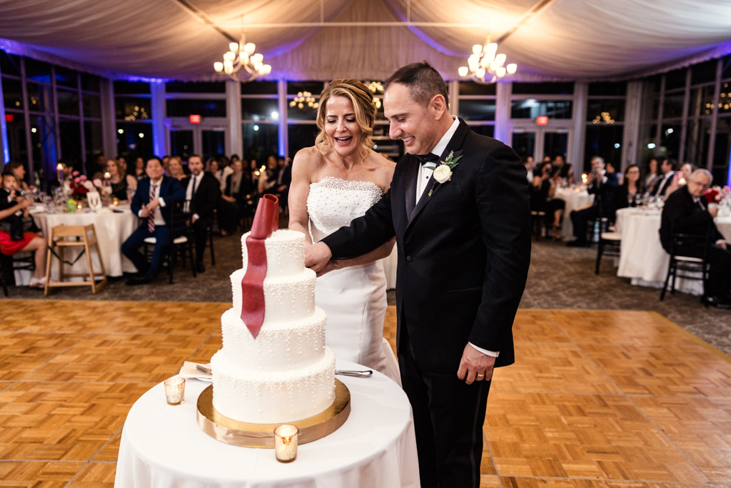 Bride and groom smile while cutting their white wedding cake at their Lincolnshire Marriott Resort wedding reception