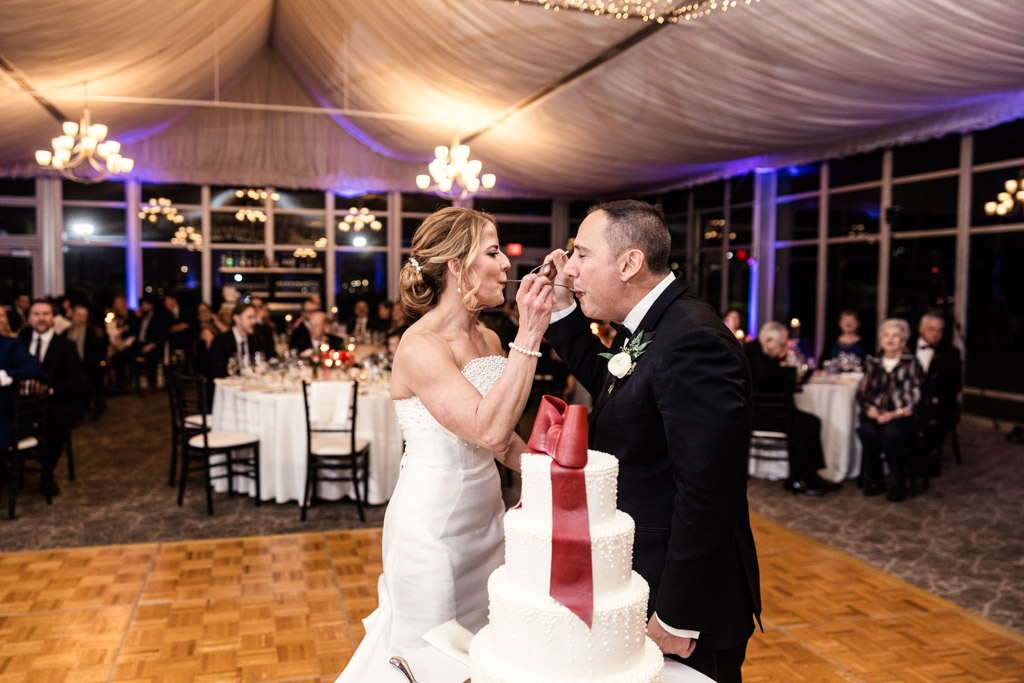 Bride and groom feed each other cake at their Lincolnshire Marriott Resort wedding reception