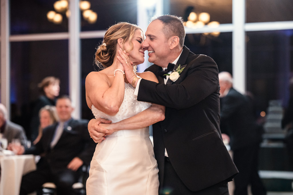 Bride and groom smile and embrace while sharing their first dance at their Lincolnshire Marriott Resort wedding reception