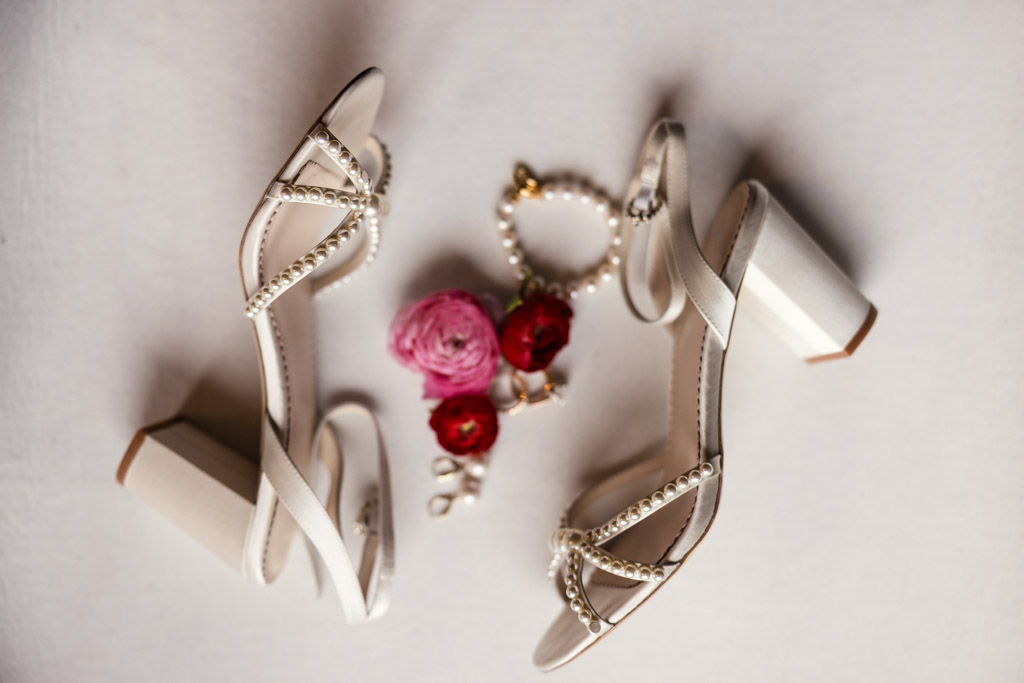 Bride's white heeled sandals with pearl straps, pink and red flowers, and pearl jewelry for Lincolnshire Marriott Resort wedding