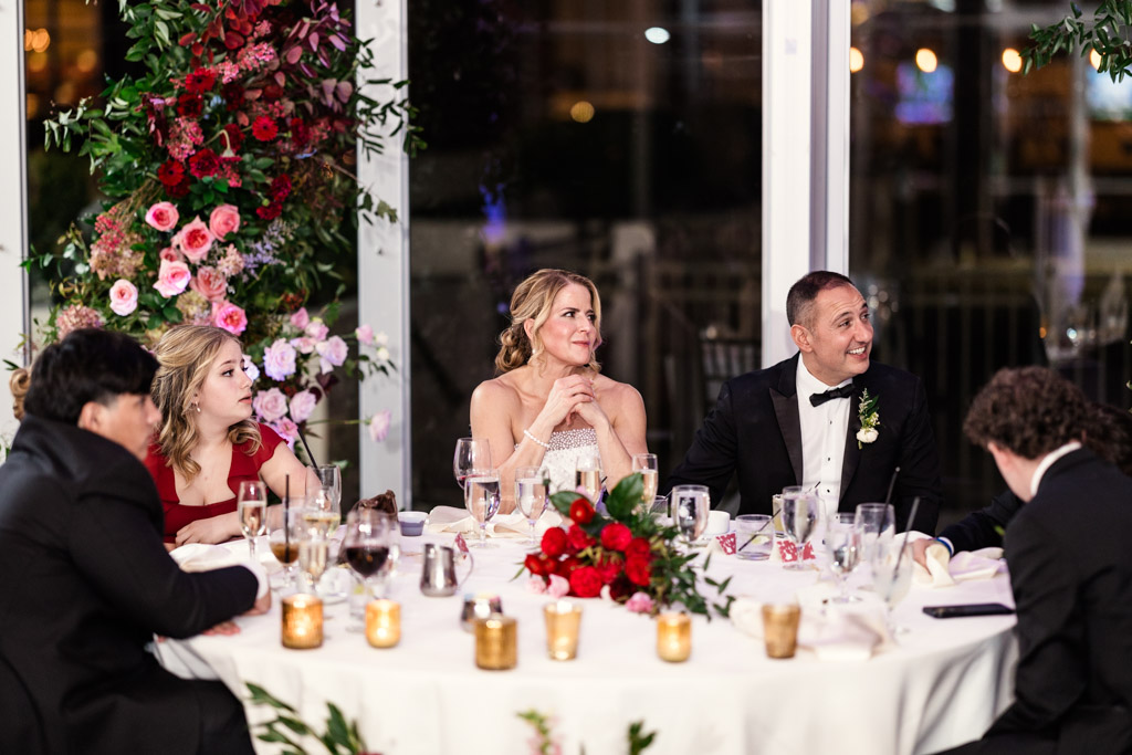 Bride and groom smile while listening to a speech during their wedding reception at Lincolnshire Marriott Resort