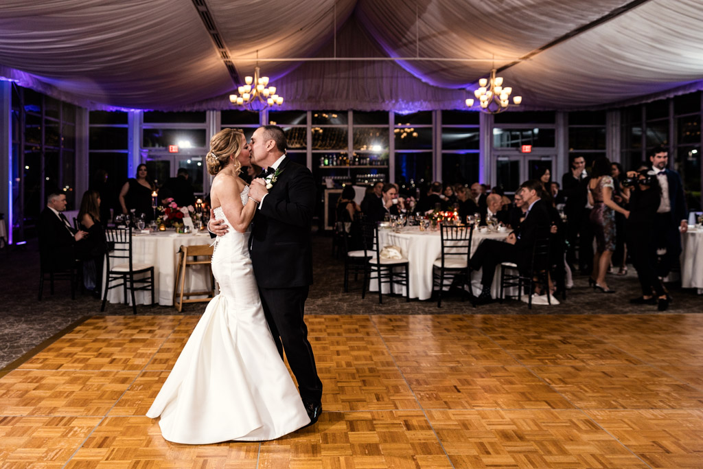 Bride and groom kiss during their first dance at Lincolnshire Marriott Resort, with guests seated at round tables