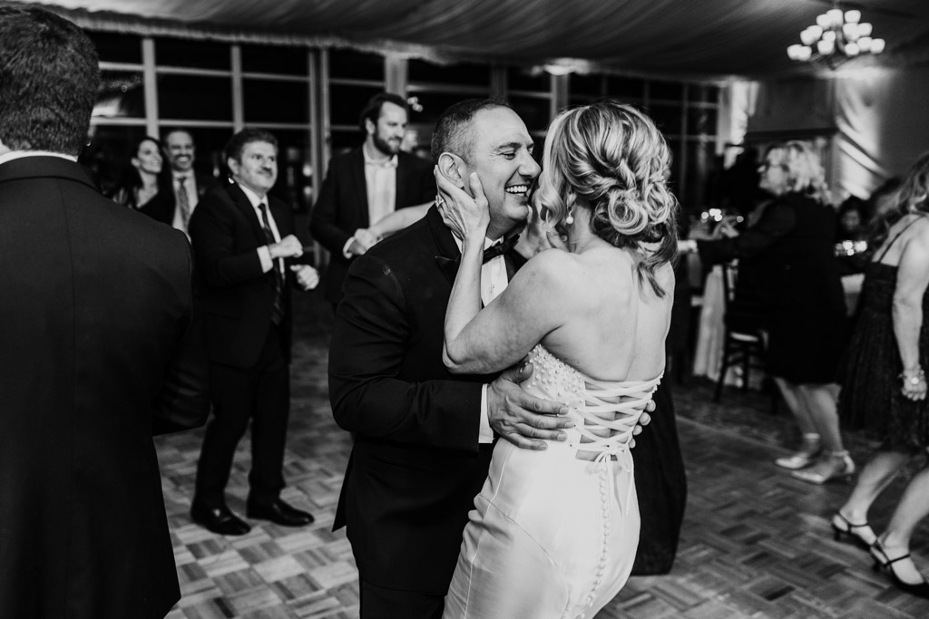 Black and white photo of newlywed couple dancing during their wedding reception at Lincolnshire Marriott Resort, smiling and surrounded by guests in elegant attire