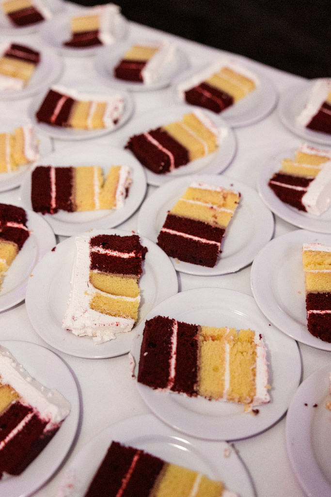 Several plates with slices of layered red velvet and yellow cake with white frosting are elegantly arranged on a white tablecloth for Lincolnshire Marriott Resort wedding reception