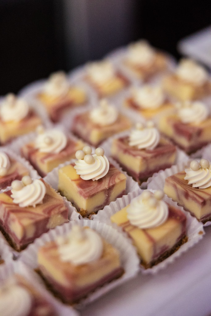 Mini cheesecake squares with swirled tops and decorative white frosting, arranged in white paper cups for Lincolnshire Marriott Resort wedding reception