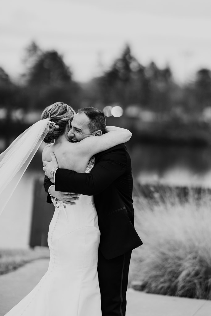 Black and white photo of bride and groom hugging outdoors during their first look at Lincolnshire Marriott Resort