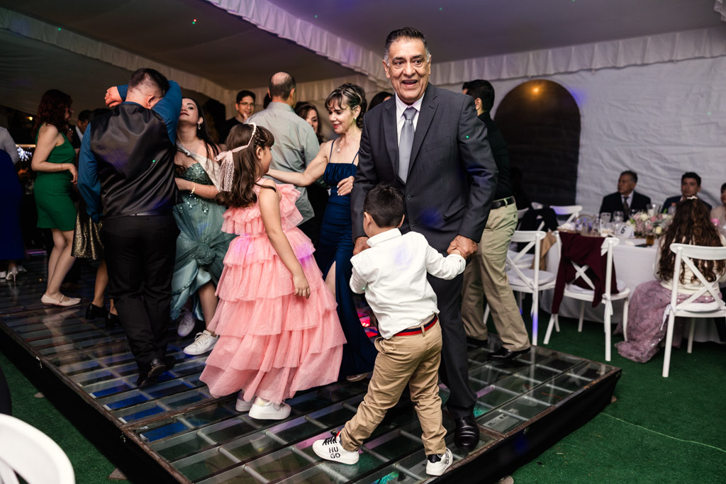Guests,\ dancing and smiling at a lively indoor Mexico City wedding celebration