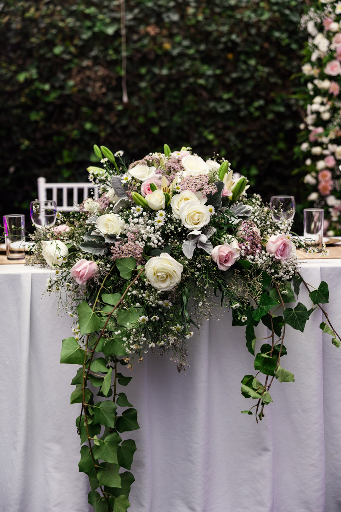 Floral arrangement with white and pink roses on a white tablecloth at Mexico City wedding reception