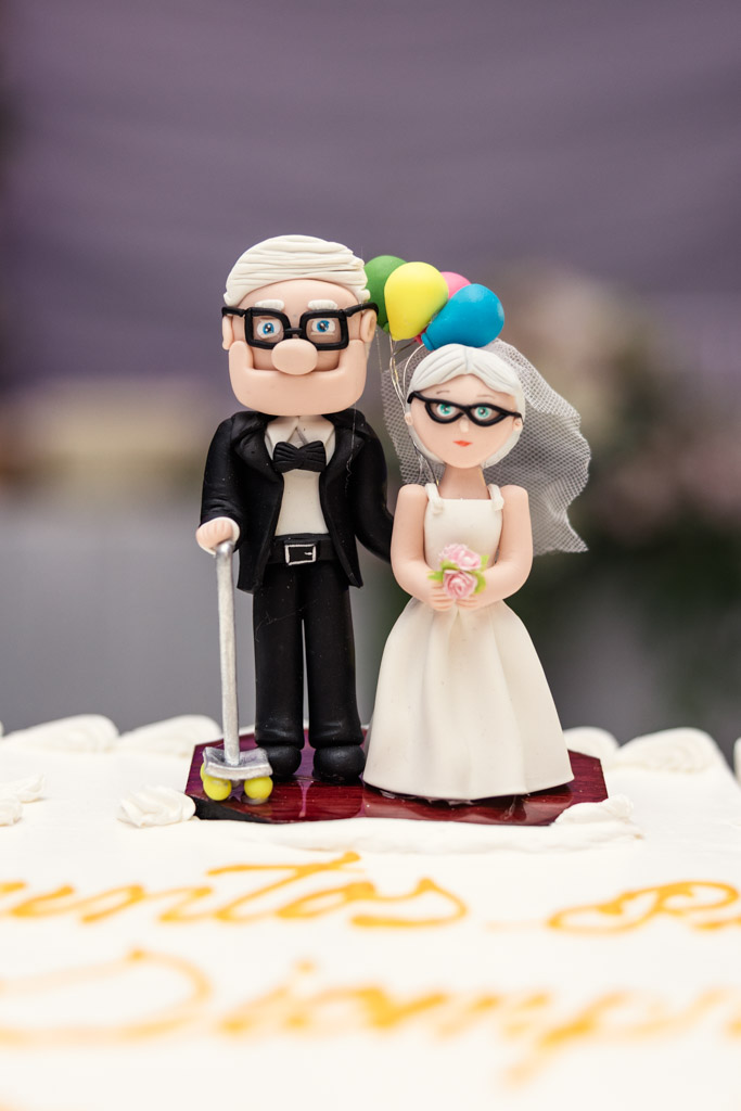 Wedding cake topper of an elderly couple with balloons, inspired by the movie 