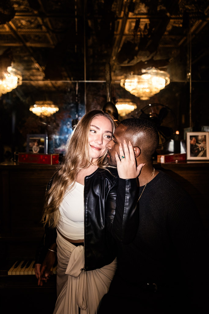 Couple poses together at the bar in Emilio's Ballato, the woman showing off a ring on her hand as she touches the man's face