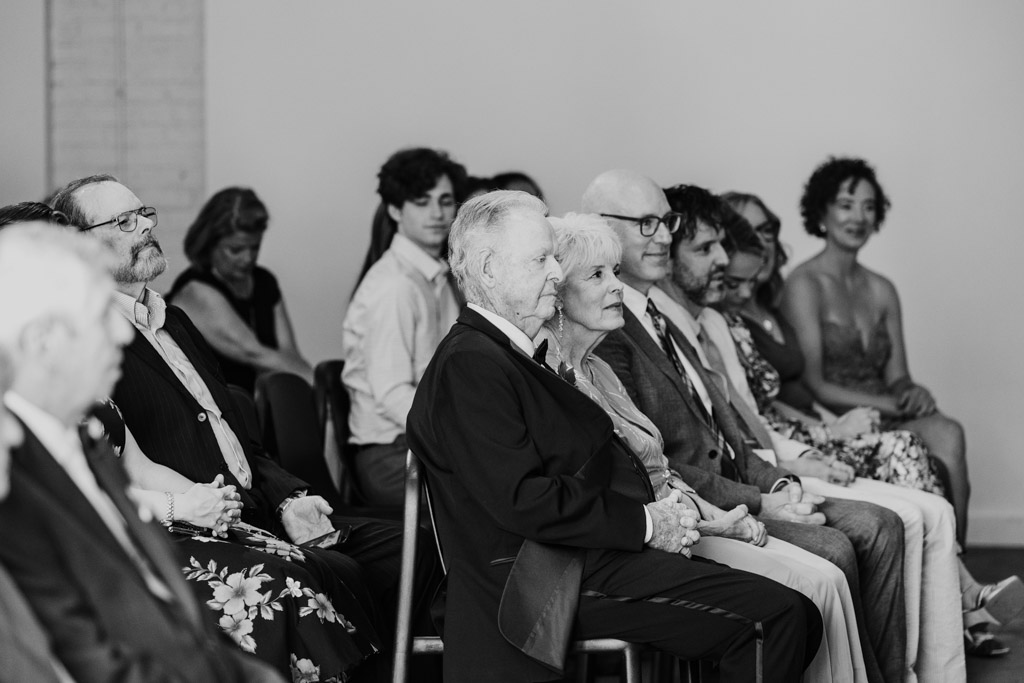 Black and white photo of bride's parents and other guests during wedding ceremony at Sarabande Chicago