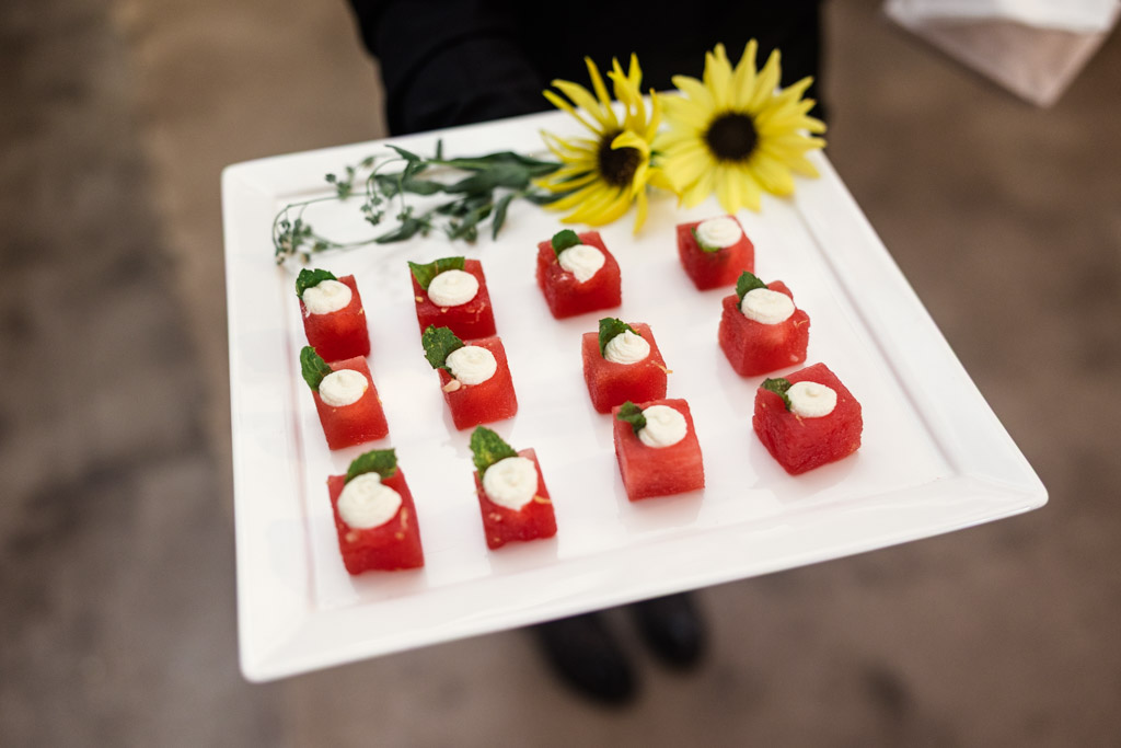 Tray of appetizers topped with cream and herbs garnished with flowers for wedding celebration at Sarabande Chicago
