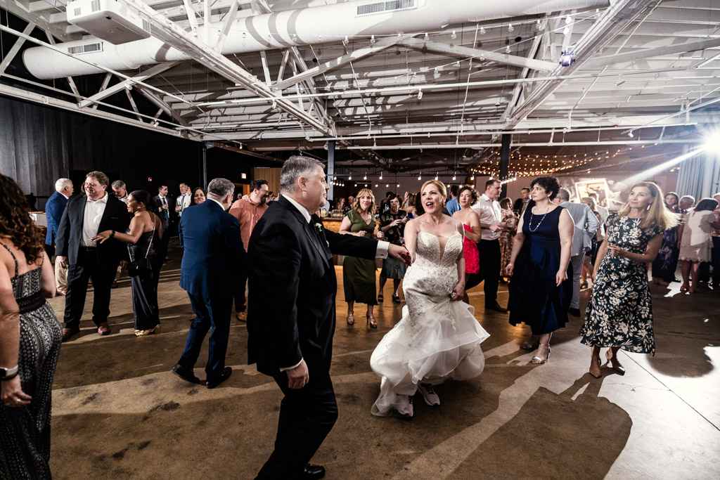 Bride and groom on the dance floor during their Sarabande Chicago wedding reception as guests watch and join in