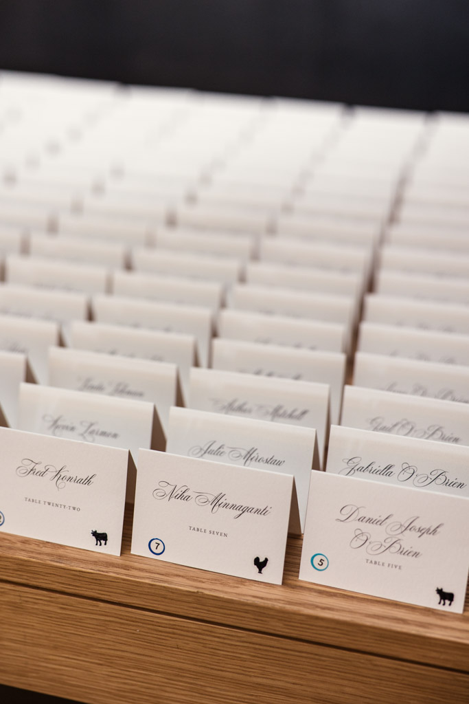 Rows of folded place cards with names arranged on a wooden table for Sarabande Chicago wedding reception