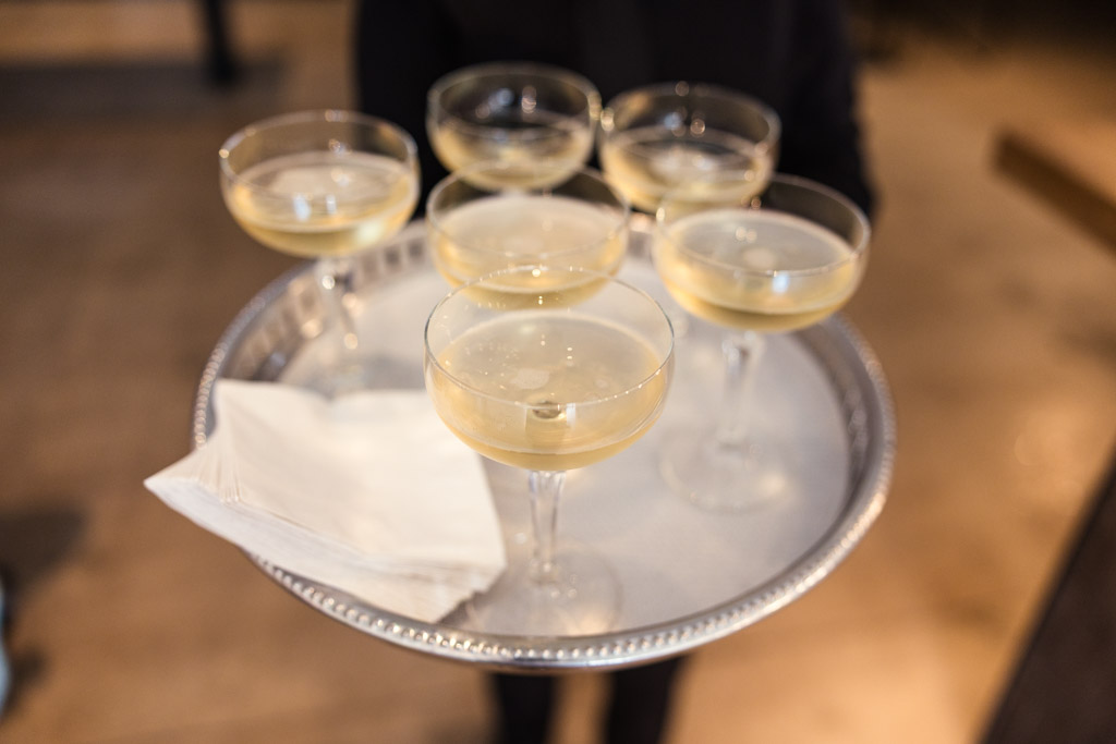 Six champagne glasses and napkins rest on a silver tray for summer wedding celebration at Sarabande Chicago