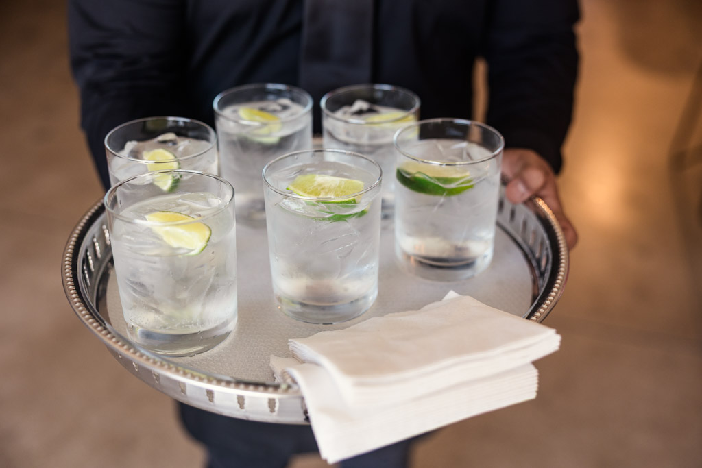 Tray with six glasses of water garnished with lime wedges, a stack of napkins for Sarabande Chicago wedding celebration
