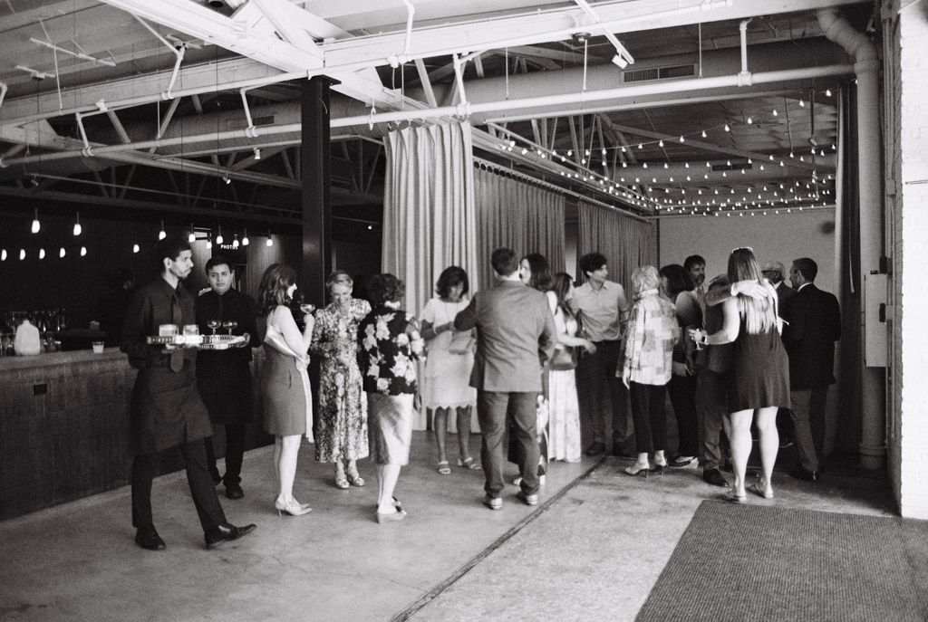 Black and white photo of guests socializing at Sarabande Chicago with string lights hanging above