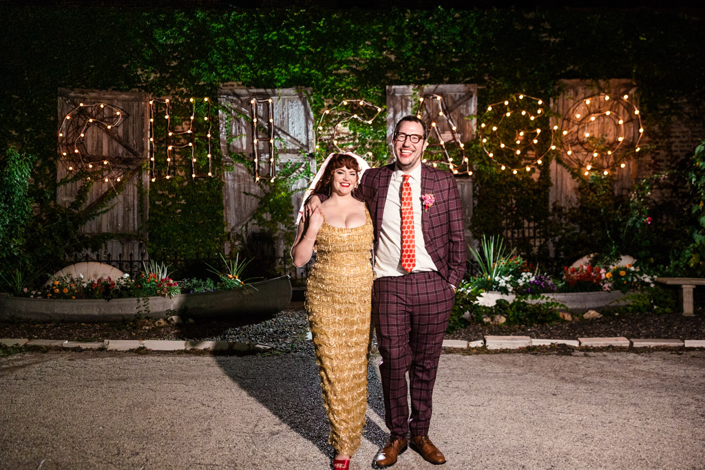 Portrait of happy newlywed couple in front of a lit 